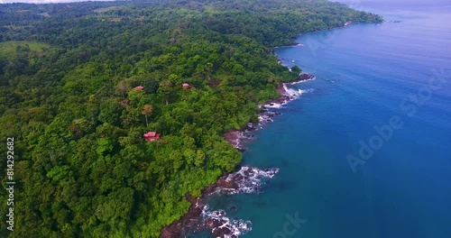 Overhead view looking down on rich blue Pacific Ocean water along a lush green forest of trees on the Osa Peninsula in Costa Rice near Drake Bay photo