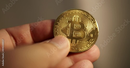 Detail of hand holding gold bitcoin coin. photo