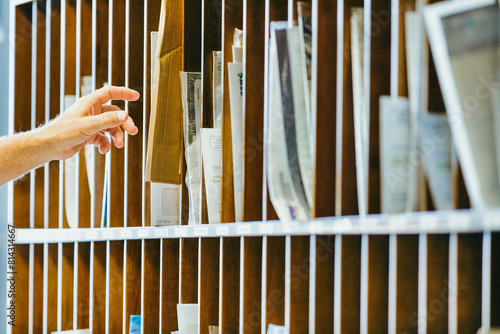 Hand reaches into wooden mail organizer, selecting