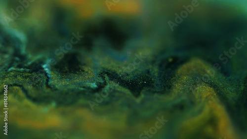Blur marble texture. Glitter paint flow. Defocused green gold yellow black color shimmering ink mix flow abstract art background.