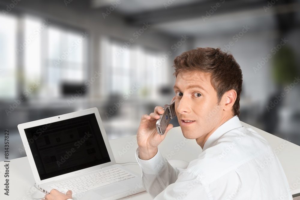 Young successful businessman at workplace with laptop Young successful businessman at workplace with laptop