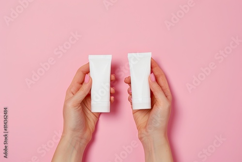 Hands holding blank white plastic tubes on pink background. Packaging for pills or capsules. Medic product branding mockup. High quality photo