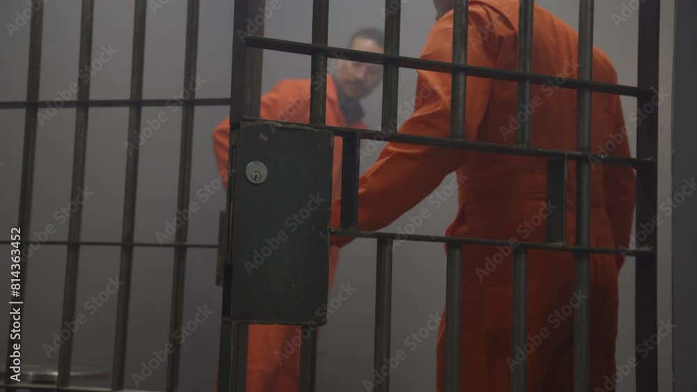 Zoom out from cell bars to inmates in jail Zoom out from cell bars to inmates in jail