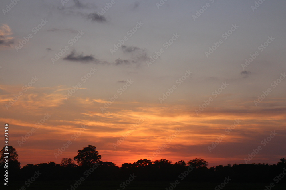 Sunset Sky Clouds in the evening with Red, Orange, Yellow and purple sunlight on Golden hour after sundown, Romantic sky in summer on Dusk Twilight