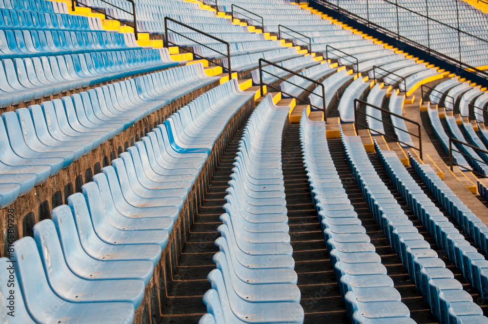 Fototapeta premium Empty seats in a soccer stadium in Latin America, a structure built amidst a ravine, providing space for both sporting and musical events.