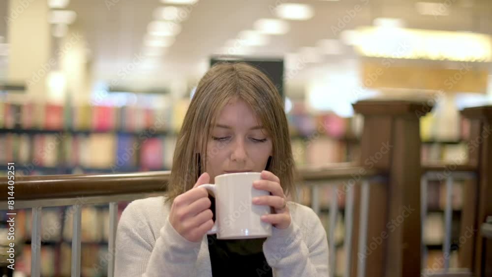 A young woman with a serene expression enjoys a warm cup of coffee in a library setting, surrounded by bookshelves filled with knowledge. A young woman with a serene expression enjoys a warm cup of coffee in a library setting, surrounded by bookshelves filled with knowledge.