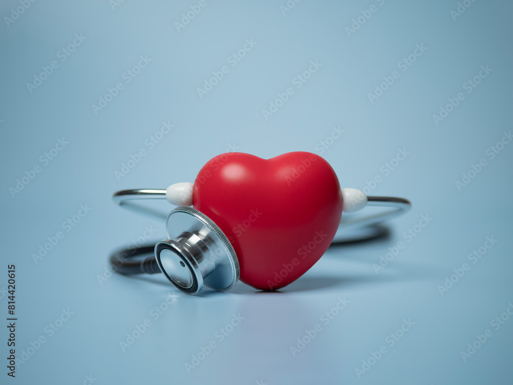 Red heart shape exercise ball with doctor physician's stethoscope on blue background, hospital life insurance concept, world heart health day. doctor day Red heart shape exercise ball with doctor physician's stethoscope on blue background, hospital life insurance concept, world heart health day. doctor day