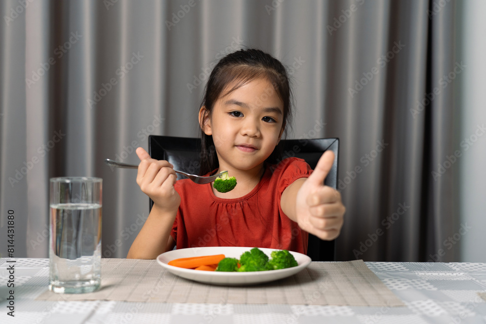 Cute little girl showing thumb showing eating healthy vegetables. Cute little girl showing thumb showing eating healthy vegetables.