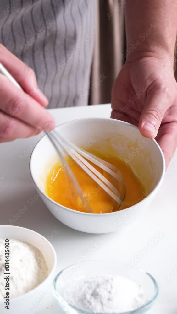 Whipping eggs in a ceramic bowl. Egg yolks and egg whites mixed with sugar. slow motion Whipping eggs in a ceramic bowl. Egg yolks and egg whites mixed with sugar. slow motion