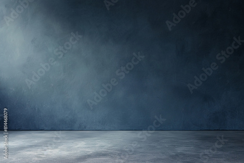 A minimalist dark blue studio backdrop with a smooth gradient  complemented by a neutral grey floor  offering ample copy space for design or text  