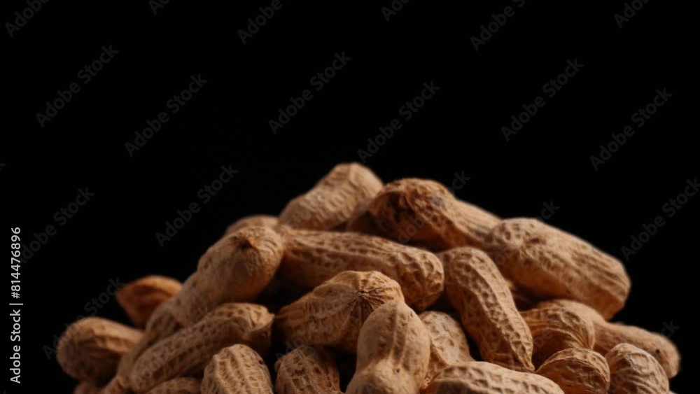 close up of spinning pile of peanuts isolated black background close up of spinning pile of peanuts isolated black background