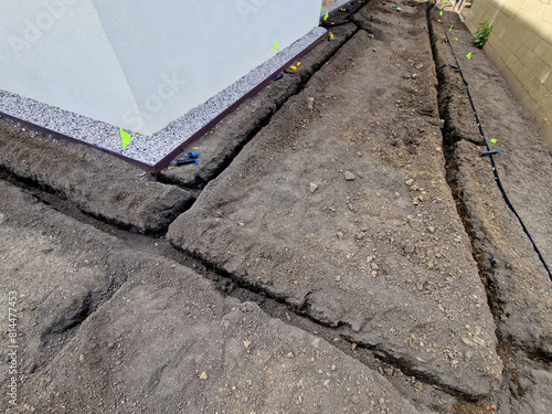 the irrigator digs grooves in the ground and fills the hoses with water. sprinklers are marked with flags. the trencher digs up the soil quickly