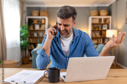 Canvas Print Frustrated business man having a phone call at his office desk