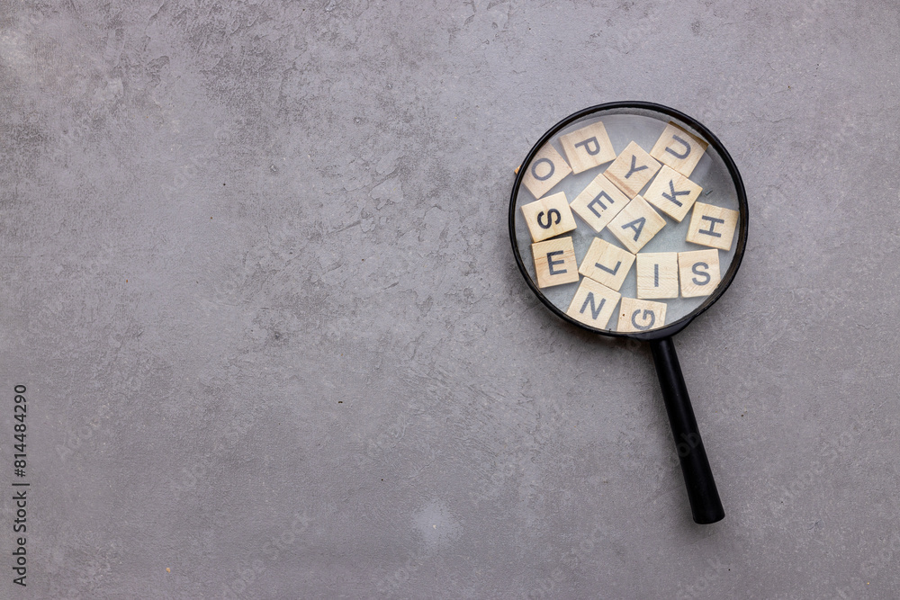 Magnifying glass with many wood letters of English alphabets, learning English concept Magnifying glass with many wood letters of English alphabets, learning English concept