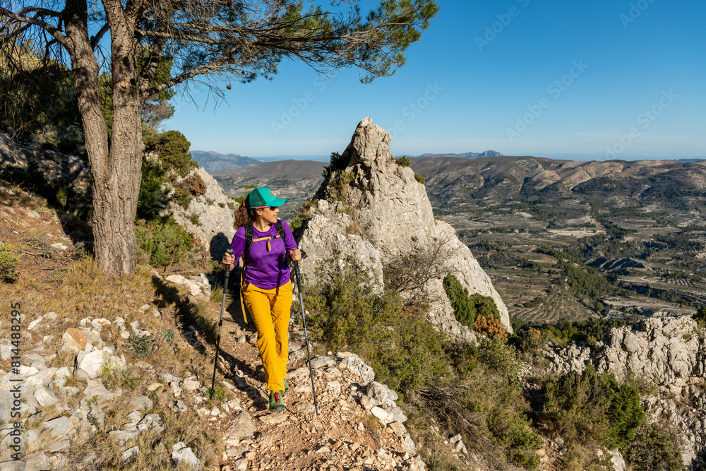Obraz premium A woman hiking in the mountains, Serrella peak, Quatretondeta, Alicante, Spain - stock photo