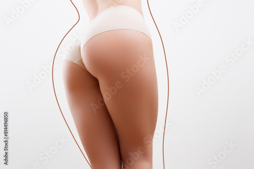 Body Shaping Spa And Slimming. Closeup cropped of unrecognizable fit woman wearing lingerie pulling up white panties standing isolated on pastel studio background. Torso of slim female with lines