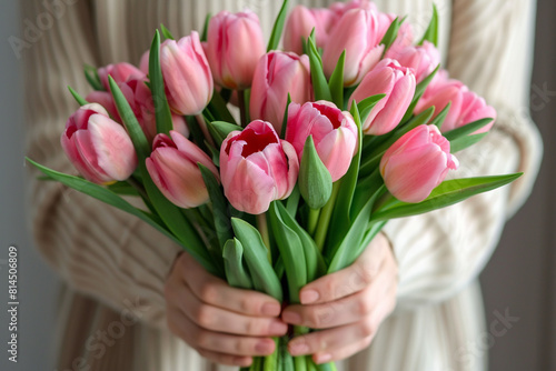 A woman holds a bouquet of pink tulips birthday, mother's day, world women's day 