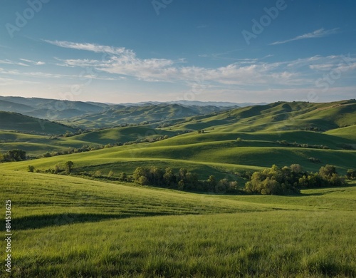 Experience the serenity of a countryside landscape with a clear blue sky and rolling green hills.