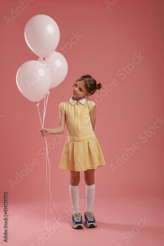 Bunch of balloons  party. Cute little girl is against pink background