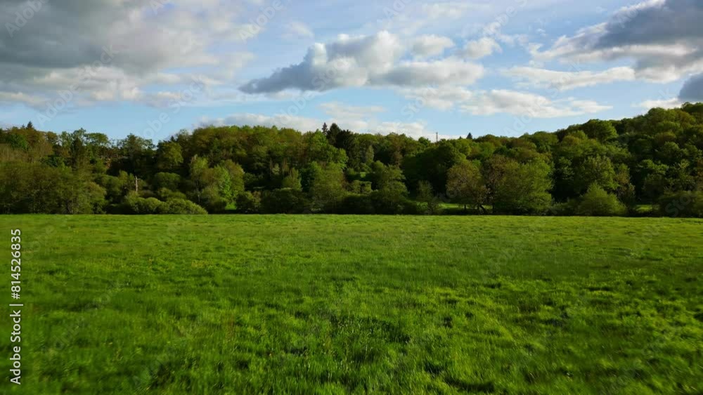 Drone flying at low altitude over green meadows in French countryside, Nouvelle Aquitaine in France. Aerial forward Drone flying at low altitude over green meadows in French countryside, Nouvelle Aquitaine in France. Aerial forward