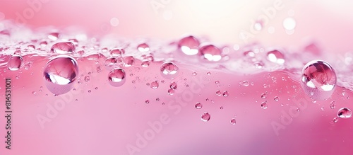 Trendy abstract summer nature background with a blurred close up view of a pink transparent water surface The texture includes splashes and bubbles making it suitable as a product advertising copy sp