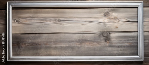 A copy space image featuring a silver frame elegantly placed against a rustic wooden background