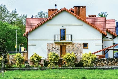 Modern house in the village. House with a beautiful roof. Architecture