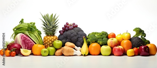 A variety of fresh fruits and vegetables arranged together on a white background for composition Ample space available for text or other elements in the image