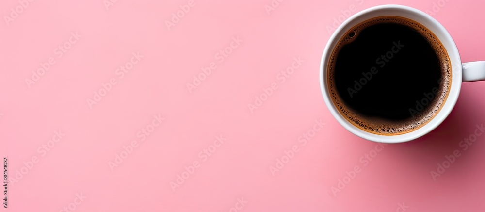 A black coffee cup is seen from above on a pink background with ample space for additional imagery or text A black coffee cup is seen from above on a pink background with ample space for additional imagery or text