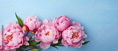 Top view of a beautiful bouquet of pink peonies on a light blue background perfect for Mother s Day Valentine s Day or birthday celebrations Includes a greeting card with copy space image