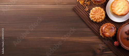 Close up copy space image of traditional Chinese mooncakes with tea cups served on a bamboo tray against a wooden background celebrating the Mid Autumn Festival