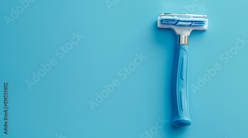 Light blue simple men's razor on a blue background. The razor has five blades and a lubricating strip. The handle is ergonomic and has a rubber grip. photo