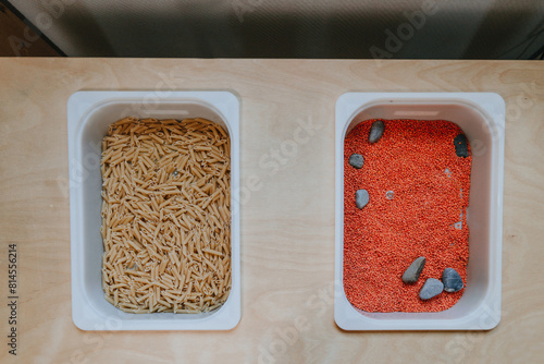 Plastic containers with lentils and pasta for developing tactility in children in kindergarten