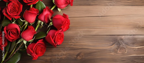 Red roses on wooden background with copy space image