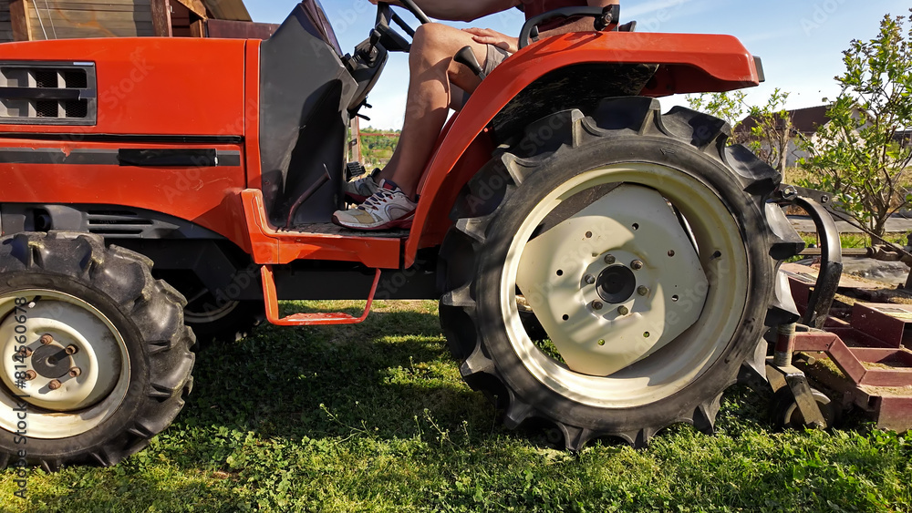 Farmer using bush hog on a tractor to cut weeds in a blueberries plant plantation. Farmer using bush hog on a tractor to cut weeds in a blueberries plant plantation.