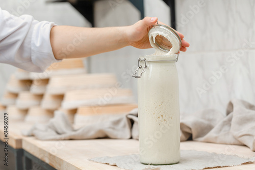 Hand-opened bottle with leaven for dough for homemade bread