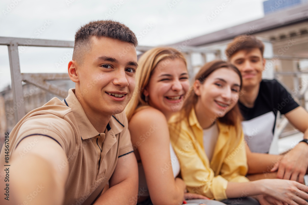 Obraz premium Four cute teenagers taking a selfie. Funny friends takes a picture of theyself
