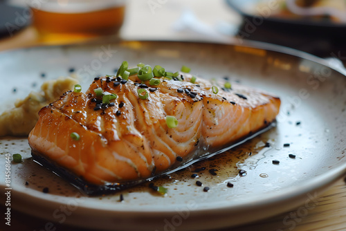 A closeup of a delicous piece of cooked salmon garnished with spring onions photo