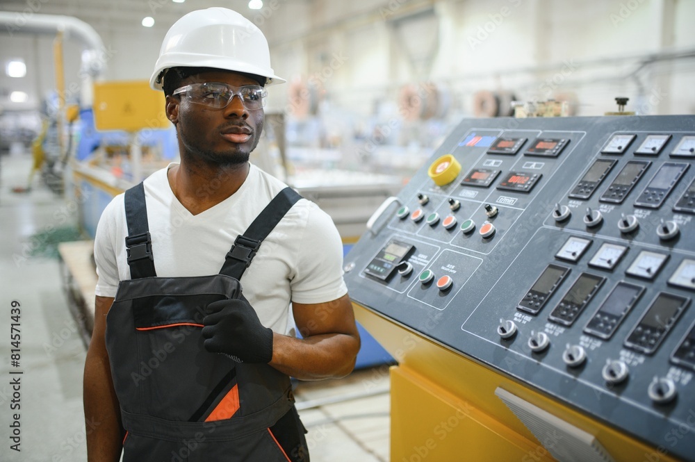 Professional Heavy Industry Engineer Worker Wearing Uniform, Glasses and Hard Hat in a Factory Professional Heavy Industry Engineer Worker Wearing Uniform, Glasses and Hard Hat in a Factory