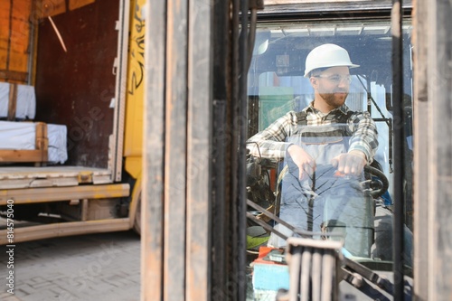 Portrait of heavy industry forklift driver giving thumbs up and smiling