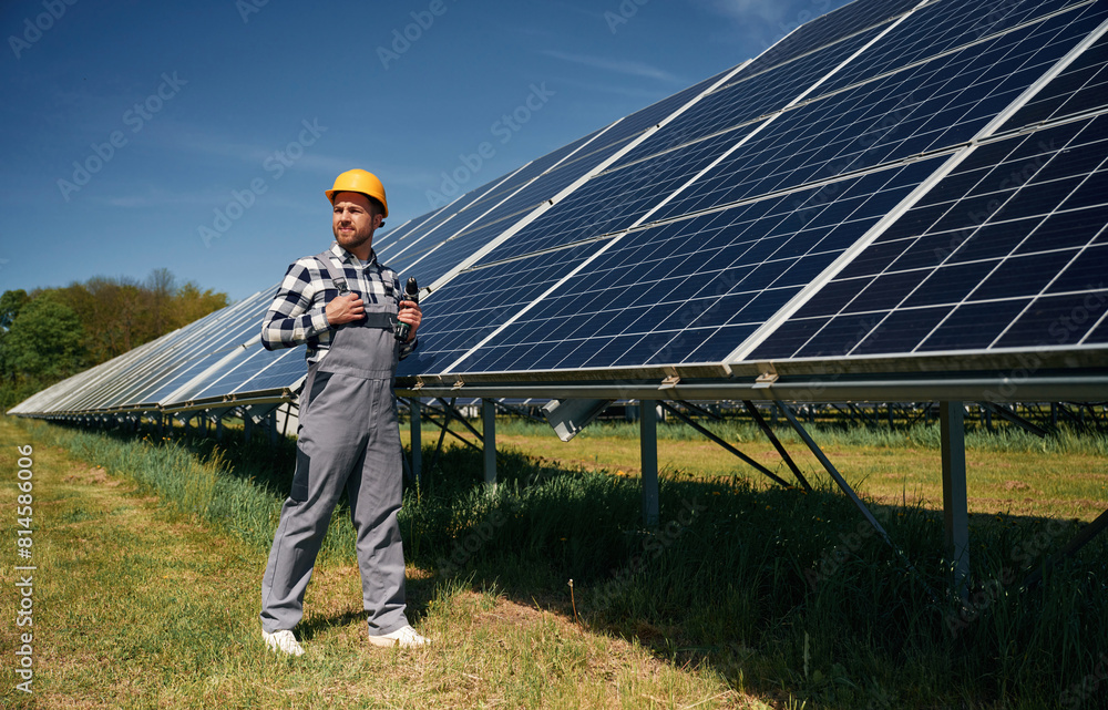 Cheerful engineer with photovoltaic solar panels outdoors at daytime Cheerful engineer with photovoltaic solar panels outdoors at daytime