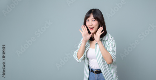 Profile view of a woman who loudly announces advertisements, news and information about discounts holding her hand near her mouth open. Lady exclaims near free space for text on green background.