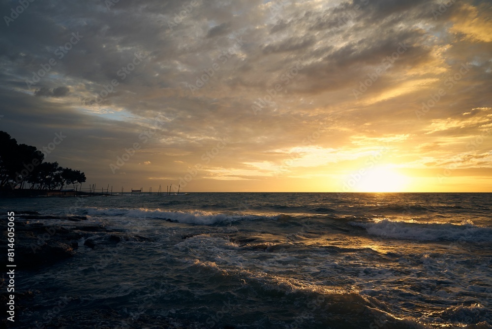 Scenic view of a tranquil beach against the sea at sunset Scenic view of a tranquil beach against the sea at sunset