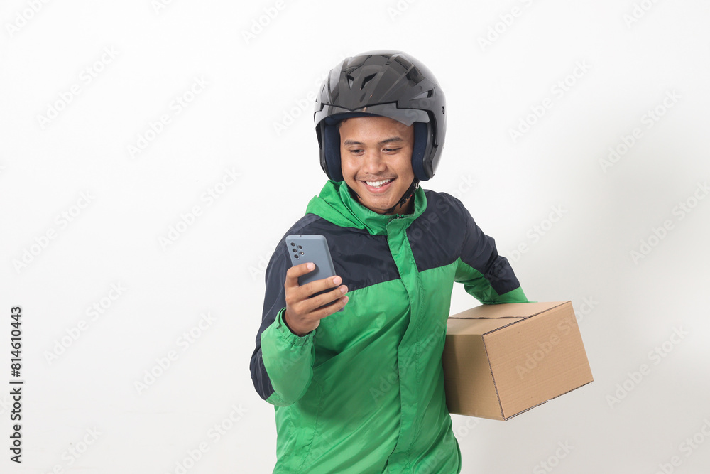 Portrait of Asian online courier driver wearing green jacket and helmet delivering package and box for customer while using mobile phone and taking order. Isolated image on white background Portrait of Asian online courier driver wearing green jacket and helmet delivering package and box for customer while using mobile phone and taking order. Isolated image on white background