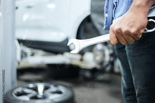 Mechanic, person and hand with wrench in workshop for maintenance, tire change and motor repair. Garage, inspection and automobile industry with tools for car service, alignment or vehicle assistance