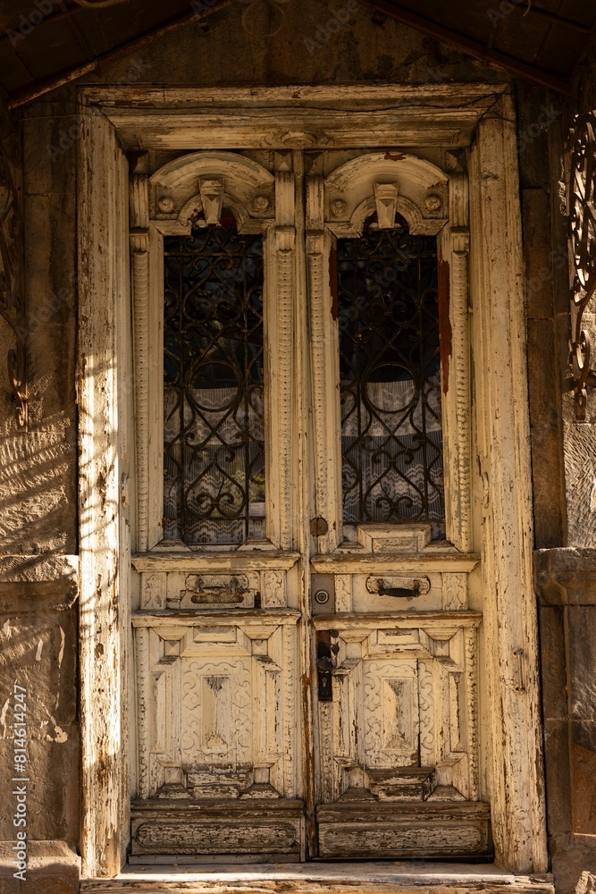 Old weathered wooden door on a crumbling stone wall of a building.