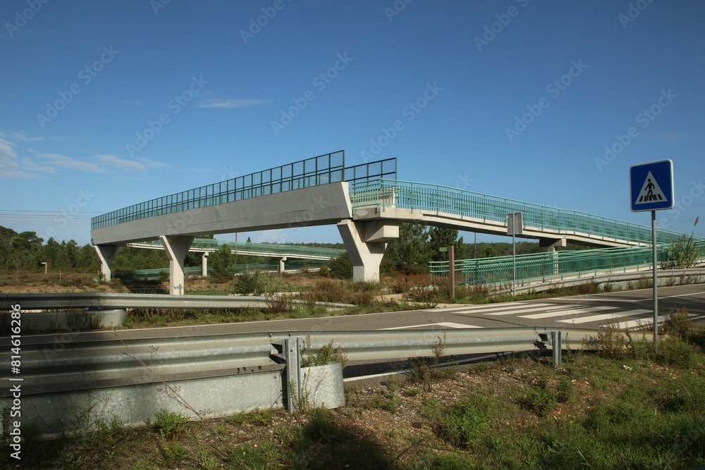 a bridge over a street next to a freeway with traffic lights a bridge over a street next to a freeway with traffic lights