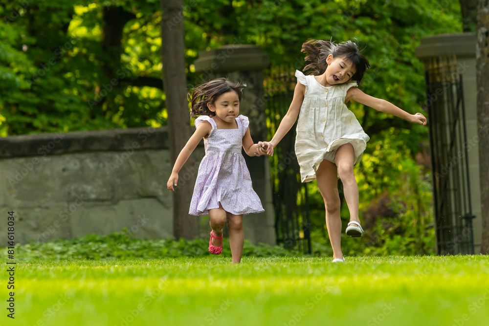 Asian sisters playing in a park during European vacation Asian sisters playing in a park during European vacation
