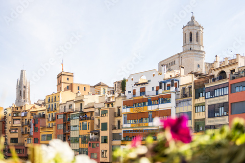 Girona, Spain - May 13th, 2024: TEMPS DE FLORS - Flower Time Festival. View of the Cathedral and the colorful houses of the Onyar river photo