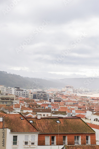Top view of the streets with white houses and orange tiled roofs, an ancient portuguese city on the ocean